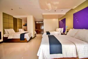 Habitación de hotel con 2 camas y pared púrpura en ECL Resort Hotel Boracay en Boracay
