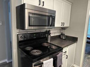 uma cozinha com um fogão e um micro-ondas em Right next to AT&T Stadium Arlington - Luxury Unit em Arlington