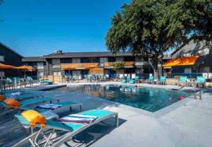 a swimming pool with chairs and a hotel at Right next to AT&T Stadium Arlington - Luxury Unit in Arlington