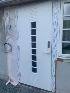 a white door on a house with a window at Tuddal - Lynnidalen Apartment in Tuddal