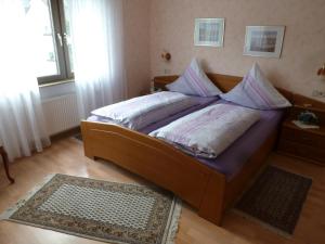 Un dormitorio con una cama grande con sábanas y almohadas moradas. en Ferienwohnungen Eckstein, en Bernkastel-Kues