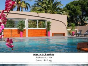 a swimming pool in front of a house at Hotel & Spa Gil de France Cap d'Agde in Cap d'Agde