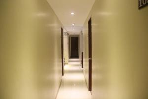 a hallway with a row of doors on the wall at Happytelle in Dipolog
