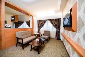 Habitación de hotel con sofá, mesa y TV en MITC Hotel en Melaka