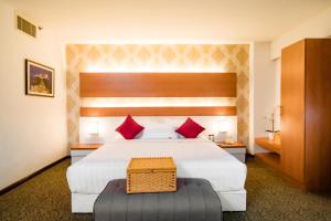 una habitación de hotel con una cama grande con almohadas rojas en MITC Hotel en Melaka