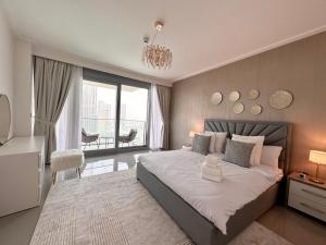 Un dormitorio con una cama grande y una lámpara de araña. en Luxurious 3 Bedroom Apartment with Burj Khalifa & Fountain View by Luxstay Holiday Homes, en Dubái