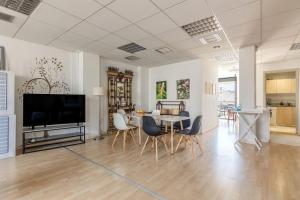 a living room with a table and chairs and a television at Downtown Spacious Loft Apartment just 3 minutes from City Centre in Heraklio Town