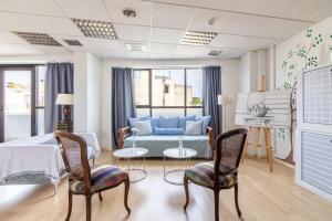 a living room with a blue couch and chairs at Downtown Spacious Loft Apartment just 3 minutes from City Centre in Heraklio Town