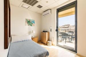 a bedroom with a bed and a balcony with a table at Downtown Spacious Loft Apartment just 3 minutes from City Centre in Heraklio Town