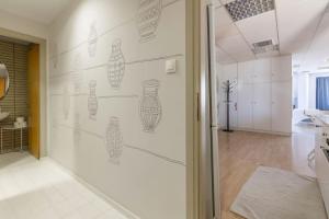 a white wall with drawings of vases on it at Downtown Spacious Loft Apartment just 3 minutes from City Centre in Heraklio Town +46 photos