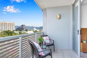 a balcony with two chairs and a view of the city at Marina View Queen Bed Studio Apartment Pool & Gym in Cairns