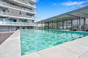 a swimming pool in front of a building at Marina View Queen Bed Studio Apartment Pool & Gym in Cairns
