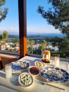 einen Tisch mit Lebensmittelplatten auf einem Tisch mit Aussicht in der Unterkunft Sarı Konak Butik Otel in Gure