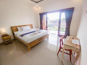 a bedroom with a bed and a table and a window at The Lucky Canggu in Canggu +40 photos