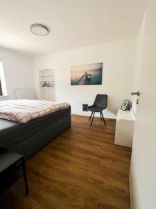 1 dormitorio con cama, escritorio y silla en Modern Apartment Wissenbach 2 en Eschenburg