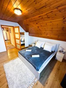 uma cama grande num quarto com tecto em madeira em Panoráma Csopak em Csopak
