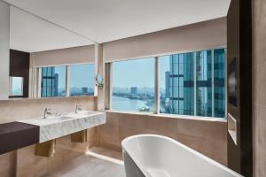 a bathroom with two sinks and a large window at Le Méridien Saigon in Ho Chi Minh City