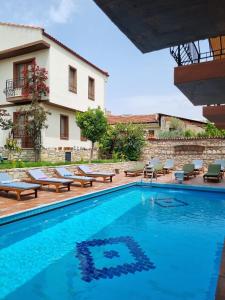 a pool in front of a building with a house at Kusadasi Sezgins Boutique Rooms in Kuşadası