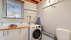 a bathroom with a washing machine and a sink at Paddys in Dinner Plain