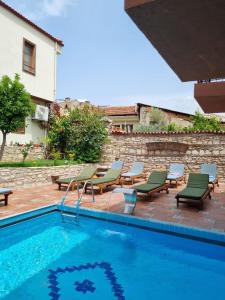 a pool with chaise lounge chairs and a swimming pool at Kusadasi Sezgins Boutique Rooms in Kusadası