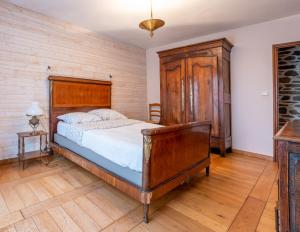 1 dormitorio con 1 cama y armario de madera en Magnifique longère bretonne., en Lanmeur