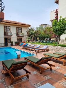 a group of lounge chairs next to a swimming pool at Sezgin Boutique Hotel in Kusadası