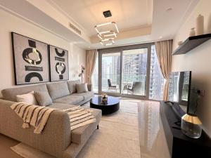 sala de estar con sofá y ventana grande en Luxurious 3 Bedroom Apartment with Burj Khalifa & Fountain View by Luxstay Holiday Homes, en Dubái