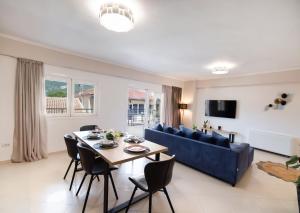 a living room with a table and a blue couch at Peratzada apartments in Vasiliki