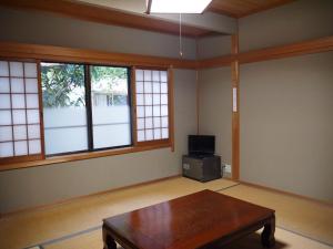 a living room with a coffee table and windows at 宿坊　光明院 in Koyasan