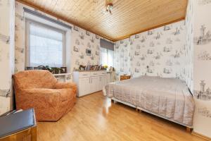 een slaapkamer met een bed, een stoel en een raam bij Elegance in the Heart of Tallinn - 150 m2 luxurious apartment with 4 large bedrooms! in Tallinn