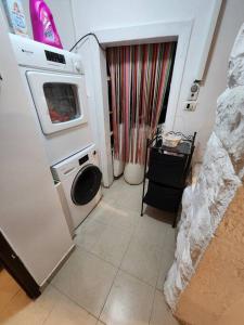 uma cozinha com uma máquina de lavar roupa e uma máquina de lavar roupa em house with a garden In the center of Nachlaot em Jerusalém