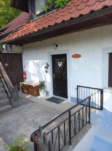a white house with a black door and a porch at APARTMENT WITH A VIEW in Bohinjska Bistrica