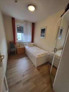 Cette chambre comprend un lit et un miroir. dans l'établissement Nah am Strand in Bensersiel, Wooge 45, à Esens