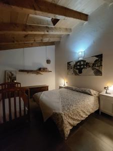 een slaapkamer met een bed, een tafel en verlichting bij Widy's House in Bussoleno