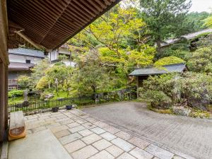einen Gehweg, der zu einem Garten mit einem Zaun führt in der Unterkunft 宿坊　光明院 in Koyasan
