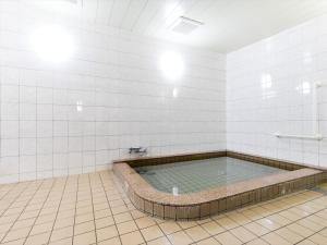 bañera en una habitación de azulejos blancos en 宿坊　光明院, en Koyasan