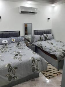 Amazing 2 bedroom Selena Bay Hurghada في الغردقة: غرفة نوم بسريرين ومرآة