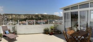 um pátio com uma mesa e cadeiras numa varanda em Sun & Sea rooftop em Costa da Caparica