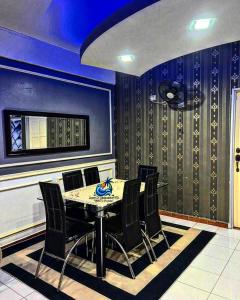 ein Esszimmer mit blauen Wänden sowie einem Tisch und Stühlen in der Unterkunft Amy D’ Homestay Jacuzzi PD in Port Dickson