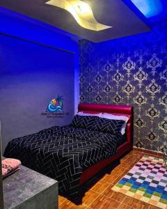 ein Schlafzimmer mit einem Bett mit blauer Decke in der Unterkunft Amy D’ Homestay Jacuzzi PD in Port Dickson