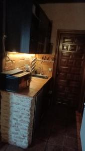 a kitchen with a counter and a sink and a door at Apartamento un Dormitorio in Valdepeñas