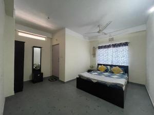 a bedroom with a bed with yellow pillows and a window at Maria's Homestay in Siliguri