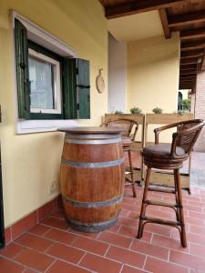 a wine barrel sitting on a patio with chairs at Le Panchette _ Pool & Bike in Salionze