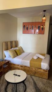 Habitación de hotel con 2 camas y mesa en Ruby Modern Homes Studio-Imara Daima,Behind Imaara Mall-JKIA-Horizon, en Nairobi