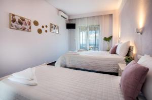 a hotel room with two beds and a window at Mani’s studios in Skala Sotiros
