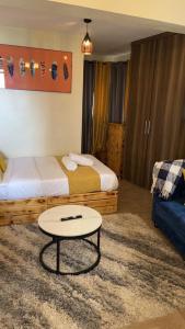 a room with two beds and a table in it at Ruby Modern Homes Studio-Imara Daima,Behind Imaara Mall-JKIA-Horizon in Nairobi