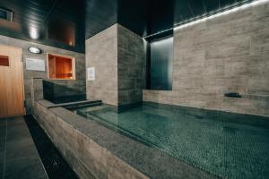 a bathroom with a pool of water in a building at 3s HOTEL HIRATSUKA in Hiratsuka