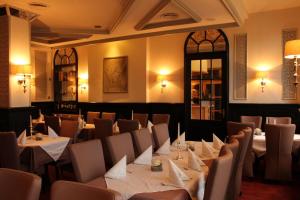 a restaurant with tables and chairs in a room at Hotel Bronnbacher Hof in Wertheim