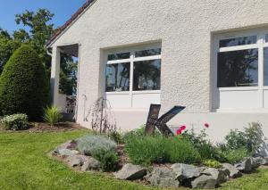 une maison avec des fenêtres et des fleurs dans la cour avant dans l'établissement Kyriad Mulhouse Est - Lutterbach, à Lutterbach
