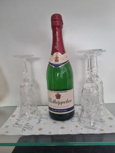 Una botella de vino y dos copas en una mesa. en Ferienwohnung *Zur Weinbergstraße* en Lauta